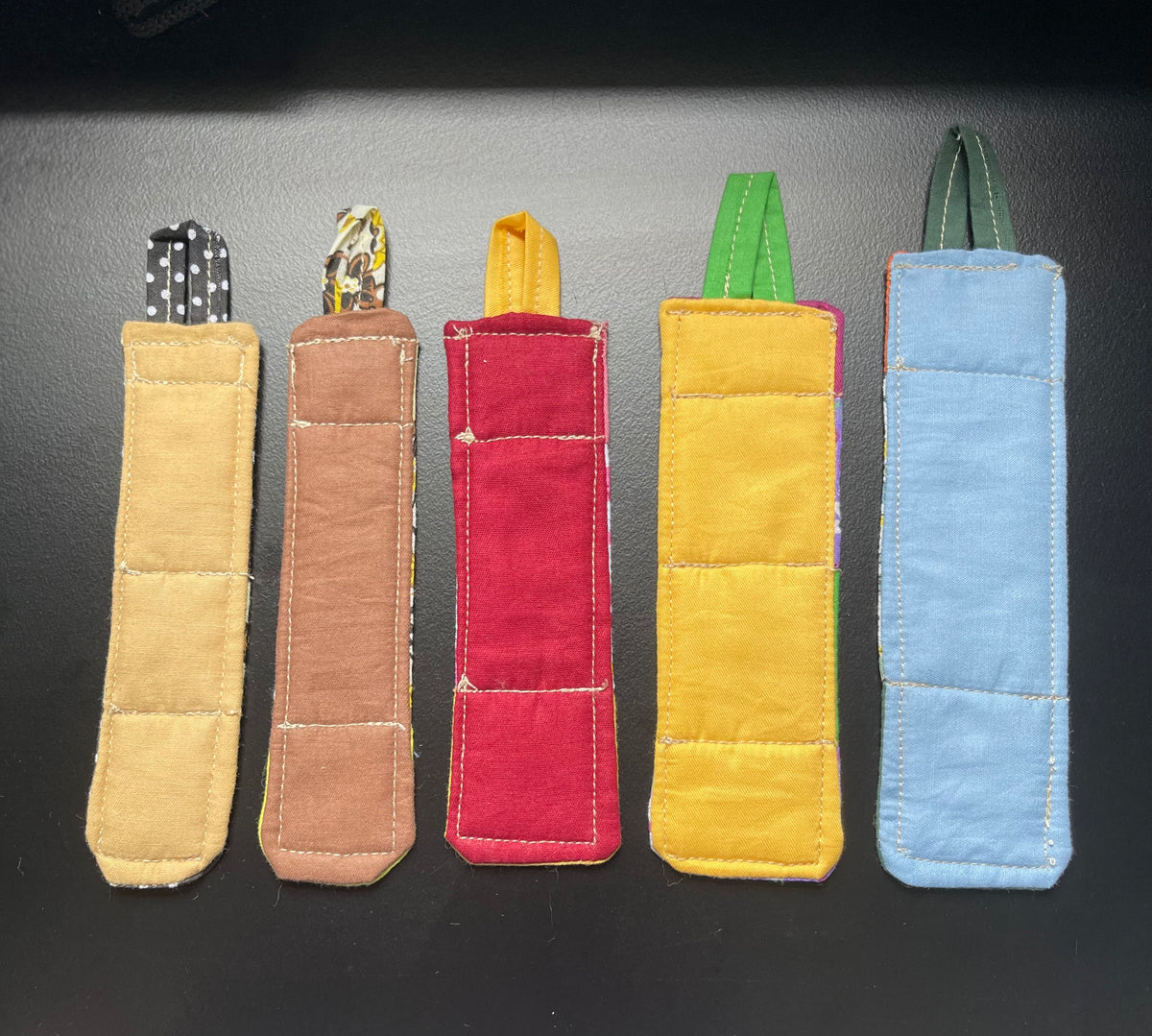 Back view of five handmade quilted bookmarks