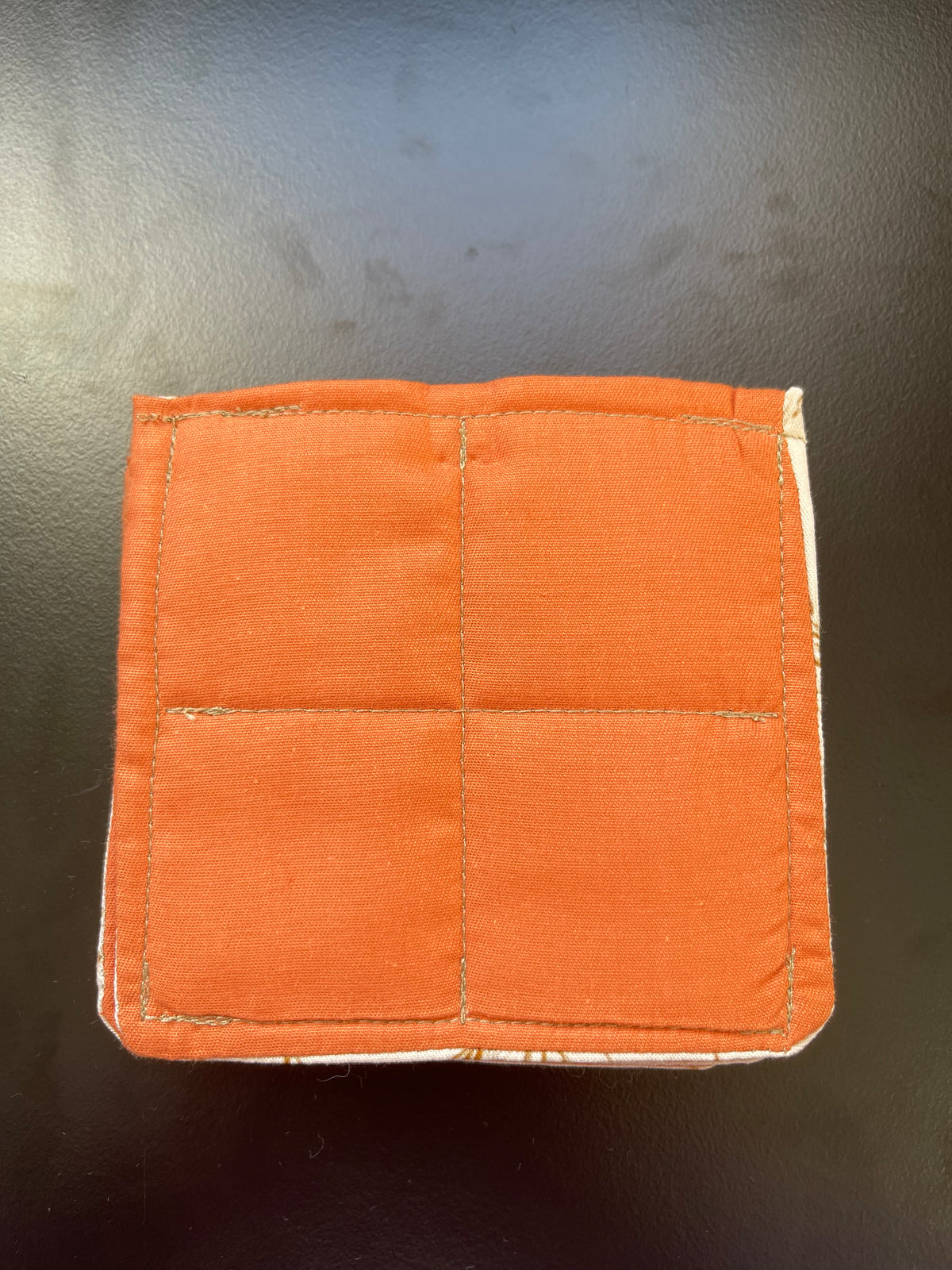 Orange reverse side of the Fields of Grace quilted coaster